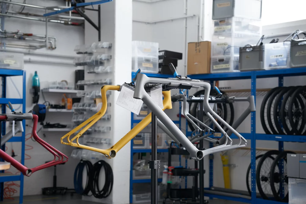 Einblick in die Urwahn Manufaktur mit jeweils drei am Fahrradmontageständer befestigten Rahmen